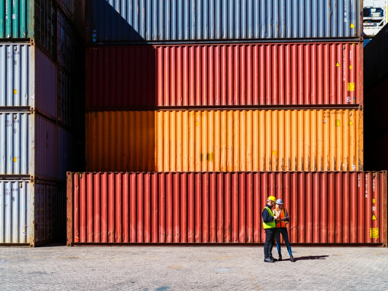Two workers having a conversation about containers